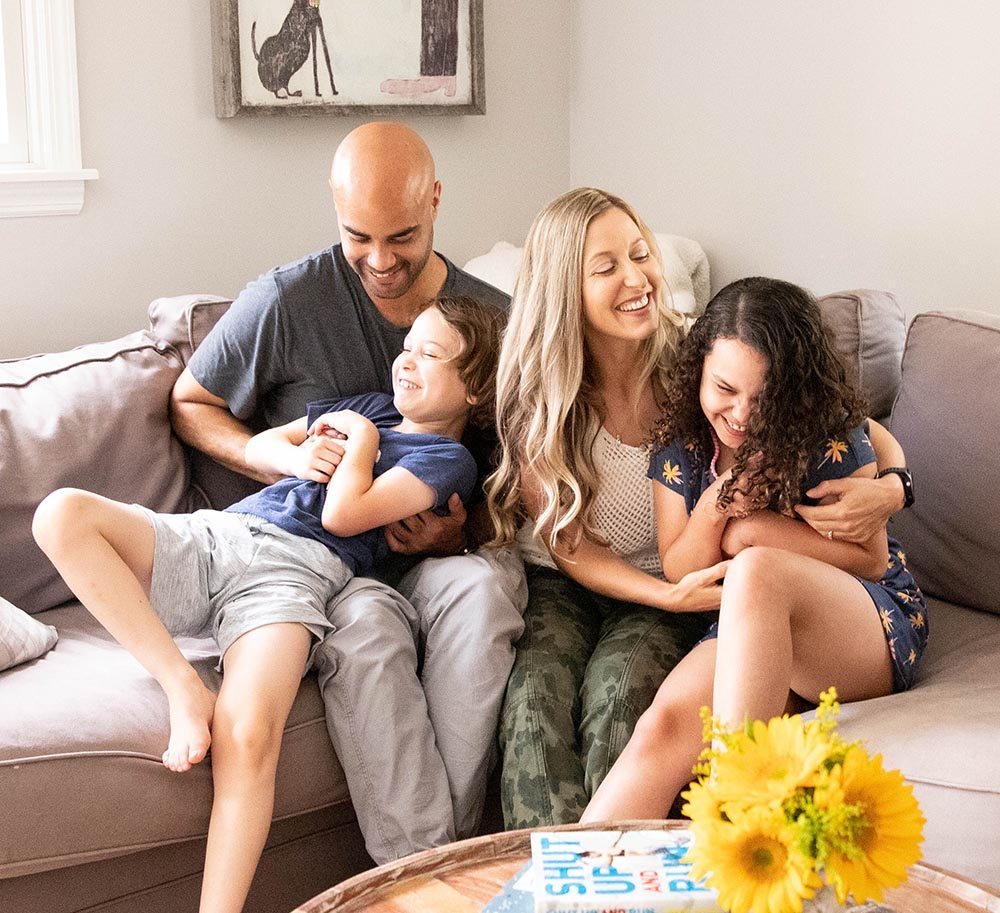 Nicole laughing on the couch with her family